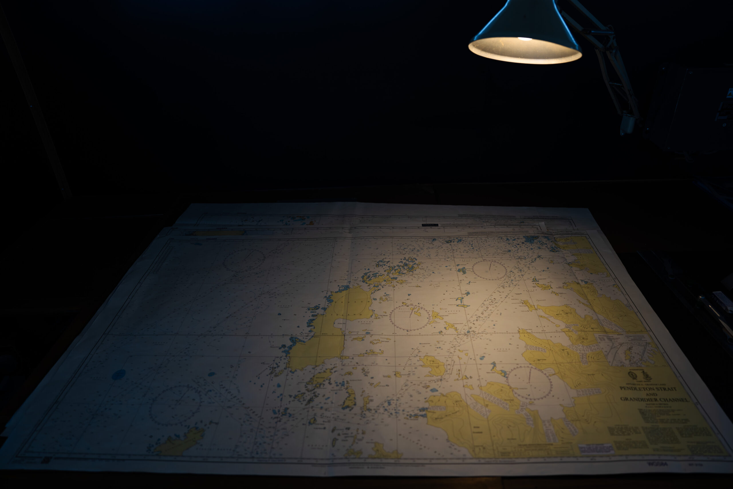 a desk lamp illuminates a map of Antarctica